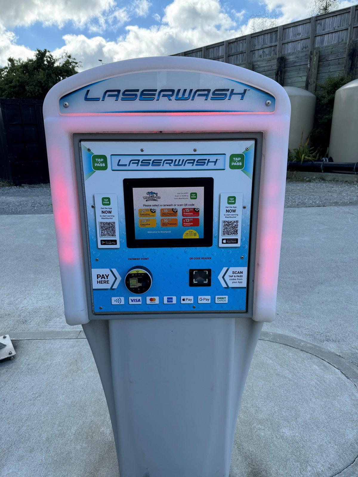 A Paydrop plinth lit up beside the wash bay at night