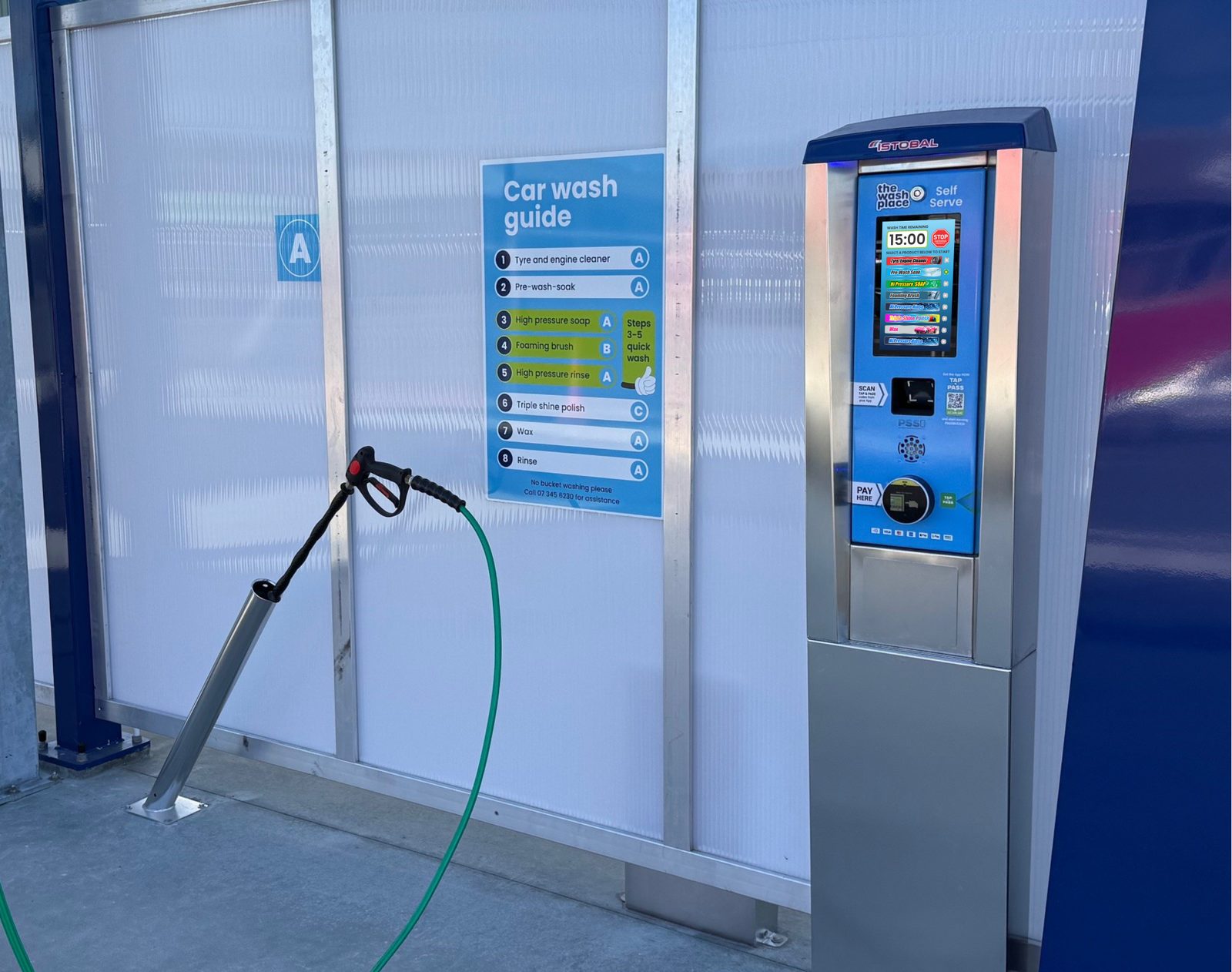 A retrofitted self-serve unit beside the car wash guide